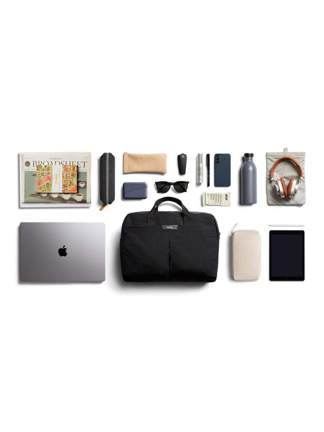 A neatly arranged flat lay of everyday essentials—magazine, pencil case, sunglasses, smartphone, water bottle, headphones, 16” laptop sleeve, cables, pen, wallet—all organized with the sleek Bellroy Tokyo Work Bag - 20L.