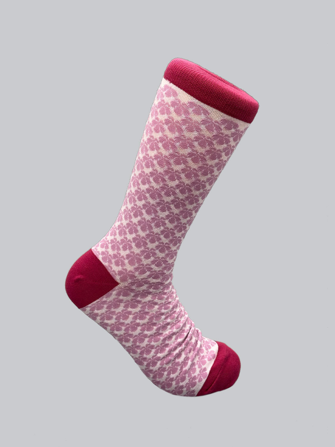 The Toyo Graphic Socks by ID Menswear feature a pink and burgundy Jacquard pattern with a solid burgundy toe and heel, set against a light gray background, highlighting the finesse of Japanese artistry.