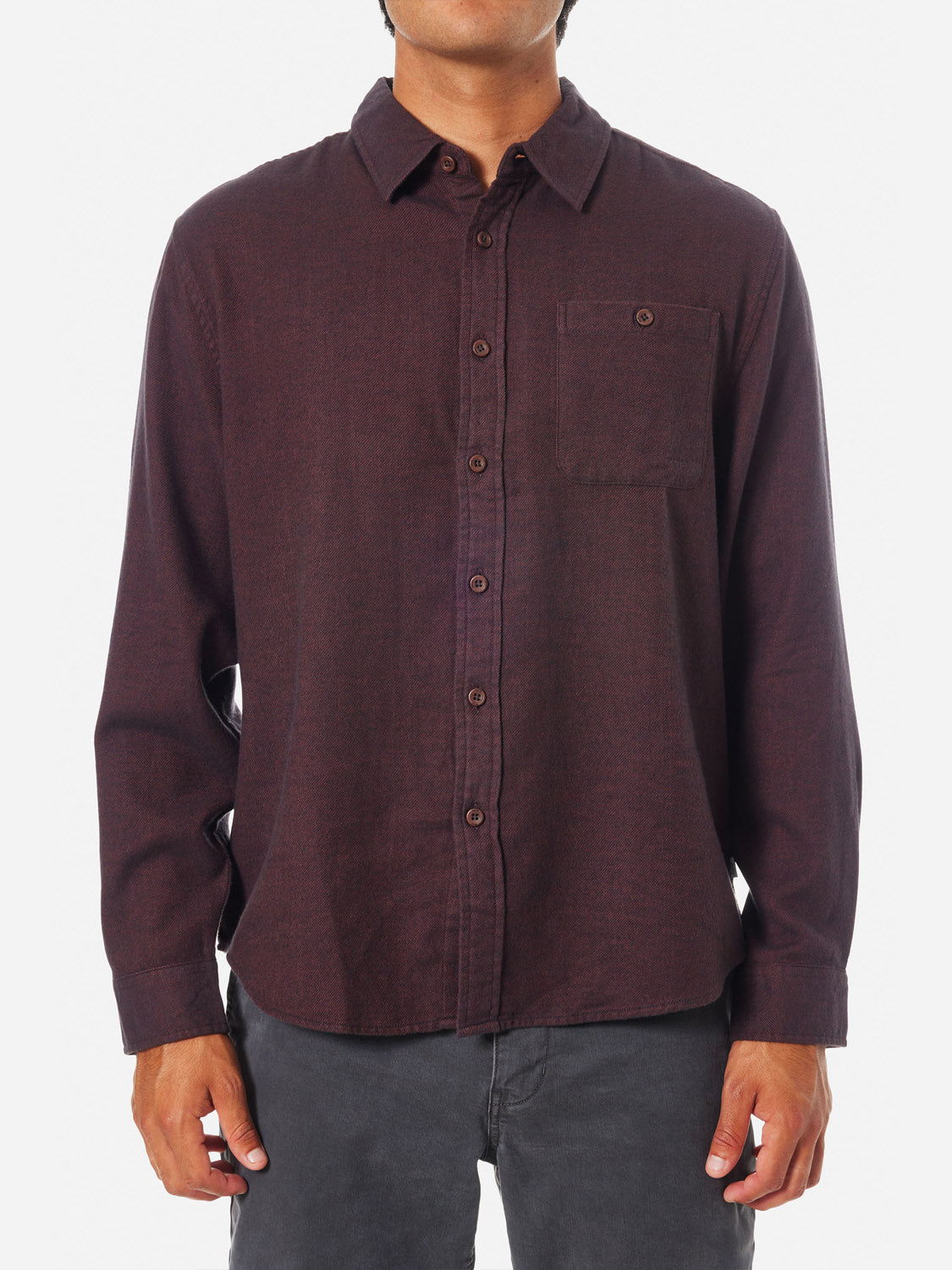 A person wears the Katin Twiller Flannel Button Down Shirt—a dark maroon, moleskin finish button-up with a chest pocket and long sleeves. They pair it with dark pants. The image shows them from shoulders to thighs against a white background.