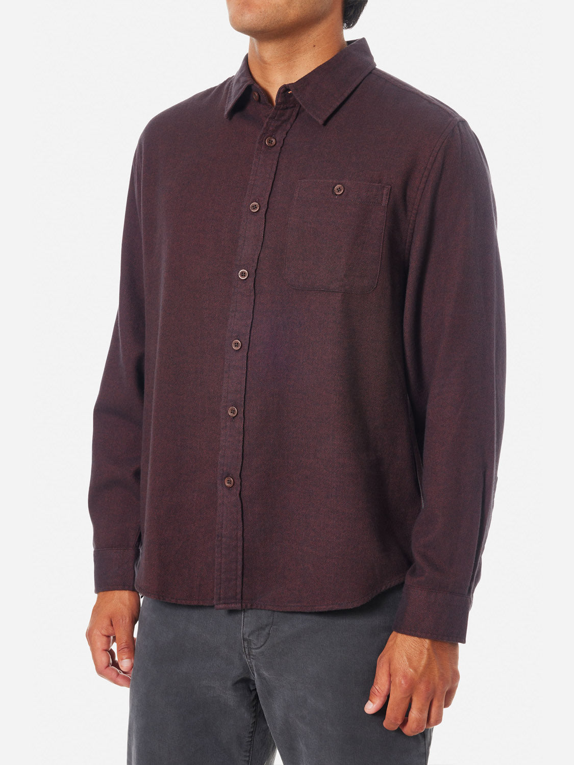A person wearing the Katin Twiller Flannel Button Down Shirt in dark brown with a moleskin finish, long sleeves, and a chest pocket, paired with dark jeans, stands against a plain white background.