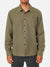 A person wearing a Katin Twiller Flannel Button Down Shirt in olive green, featuring long sleeves and a front chest pocket, stands against a plain white background. The face is not visible.