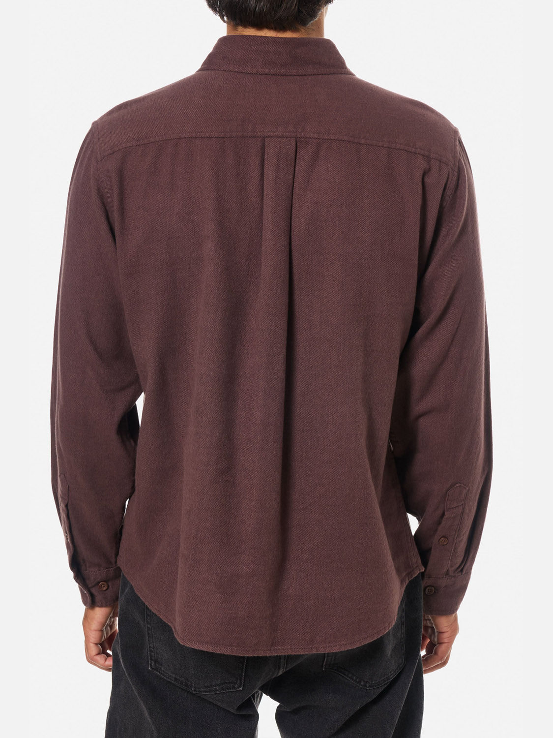 A person is seen from the back wearing a Katin Twiller Flannel Button Down Shirt in dark maroon, untucked with black pants, against a plain white background. The long-sleeve shirt is 100% cotton and features button-up styling.