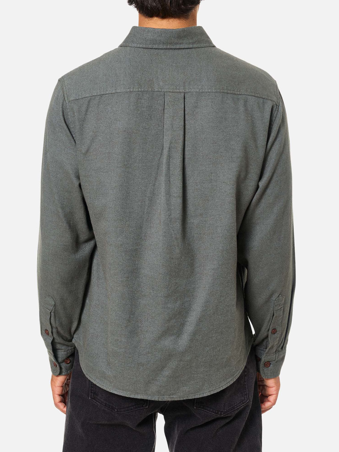 A person with short dark hair is seen from behind, wearing Katin’s Twiller Flannel Button Down Shirt in grey-green cotton twill and dark pants, standing against a plain white background.