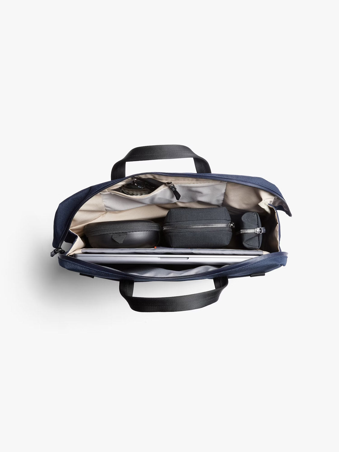 Top-down view of the Bellroy Via Work Bag - 14L in navy, with black handles and compartments made from recycled fabric—includes small cases, a zippered pouch, and a padded laptop sleeve inside.
