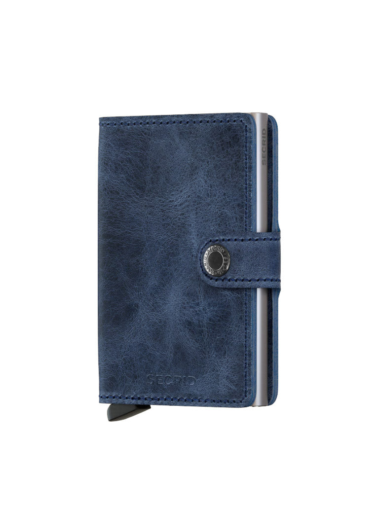 The Secrid Miniwallet Vintage Leather in blue offers RFID protection, a snap closure, a visible card section, and is designed for compact storage and easy access.