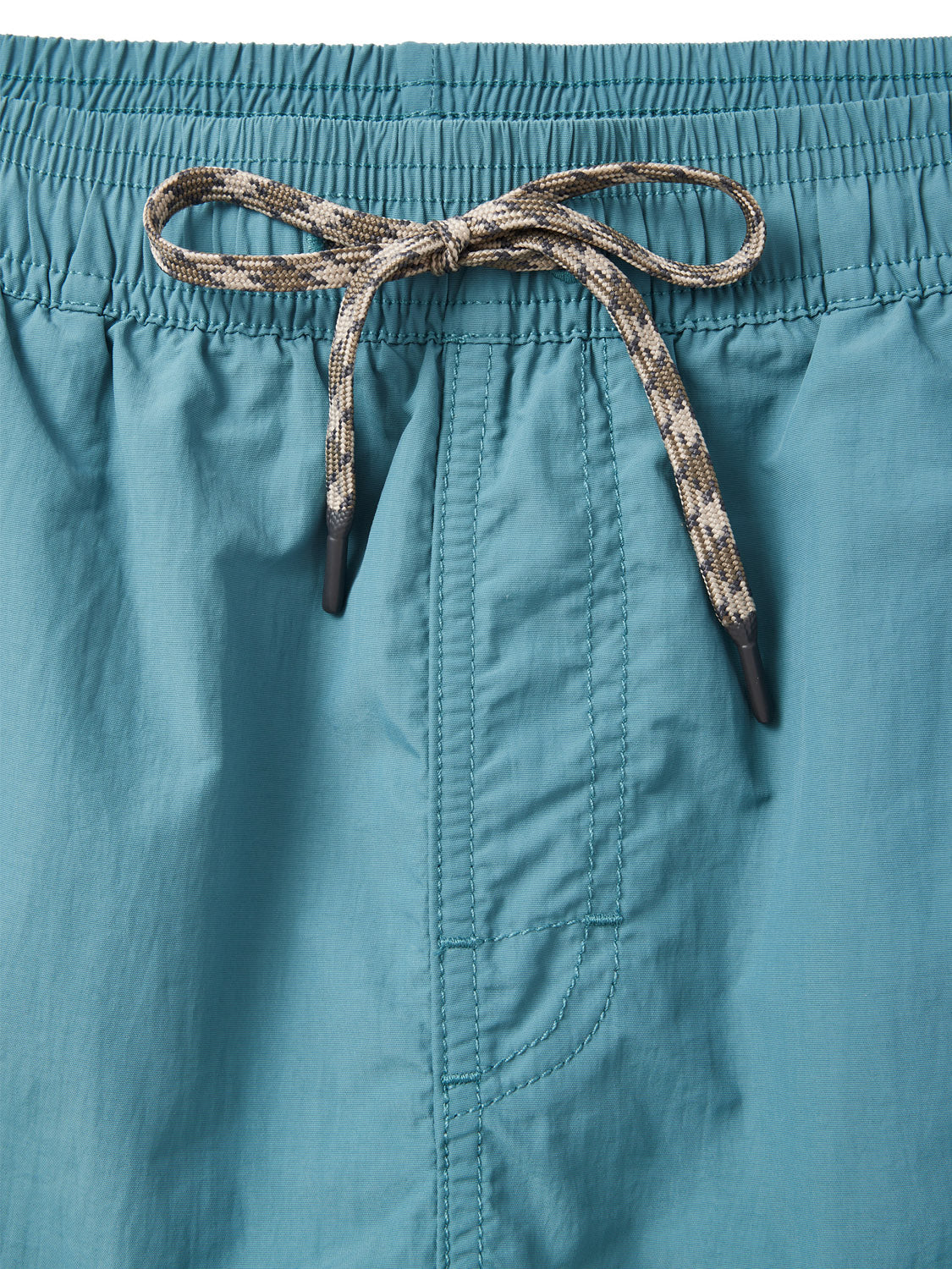Close-up of Katin Poolside Volley nylon shorts in teal, featuring an elastic waistband and a black-and-tan patterned drawstring tied in a bow at the front. Vertical stitching is visible near the center. Brand: Katin.