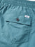 Close-up of the Katin Poolside Volley shorts in teal, made from lightweight nylon with a crinkled texture, an elastic waistband, buttoned back pocket, and small sewn-in Katin label.