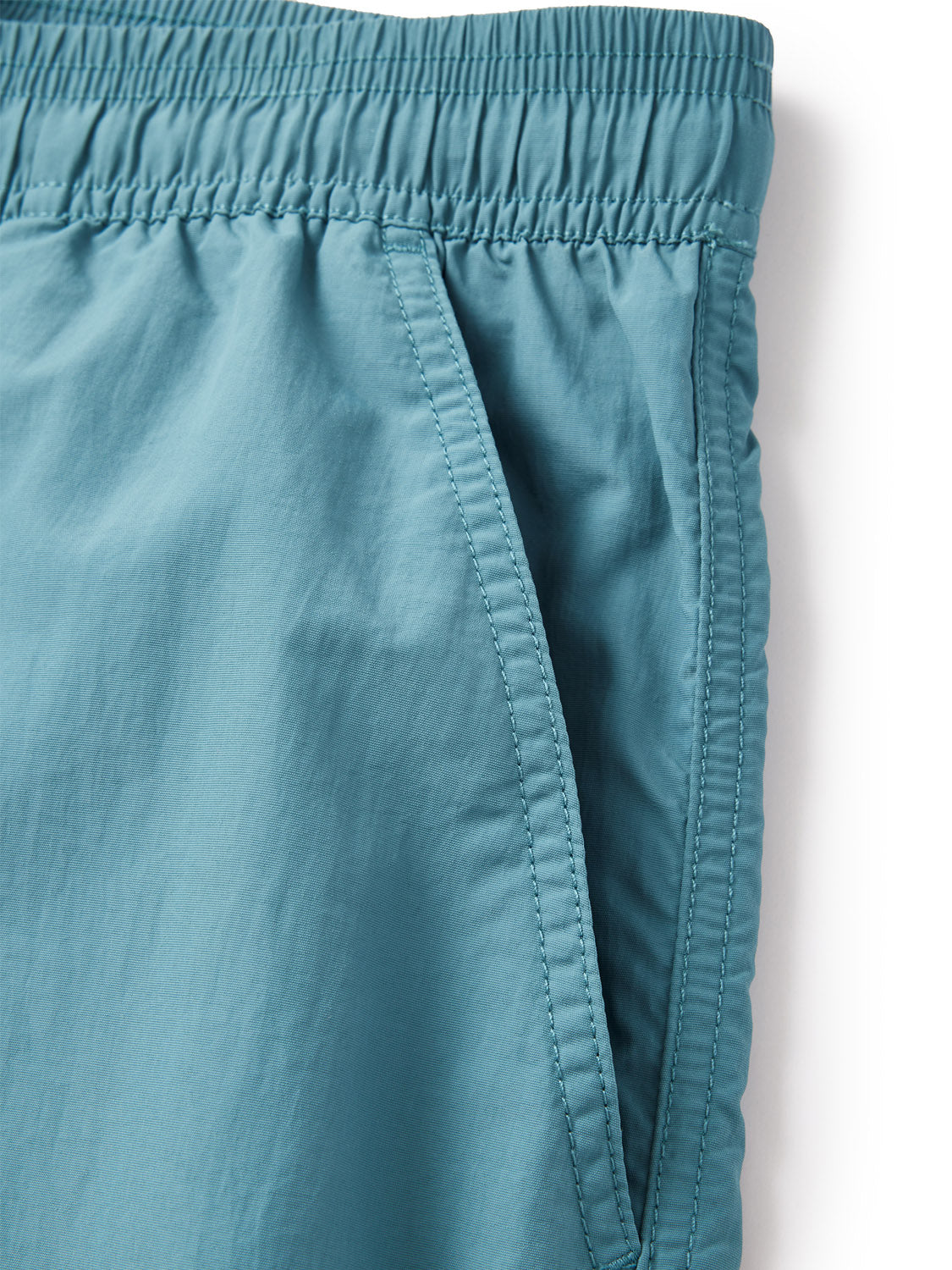 Close-up of the Katin Poolside Volley shorts in teal by Katin, featuring an elastic waistband and a side pocket with visible stitching.