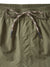 Close-up of Katin Poolside Volley olive green nylon shorts by Katin, with an elastic waistband and beige-black patterned drawstring tied in a front bow. Distinct vertical stitching detail appears below the waistband.