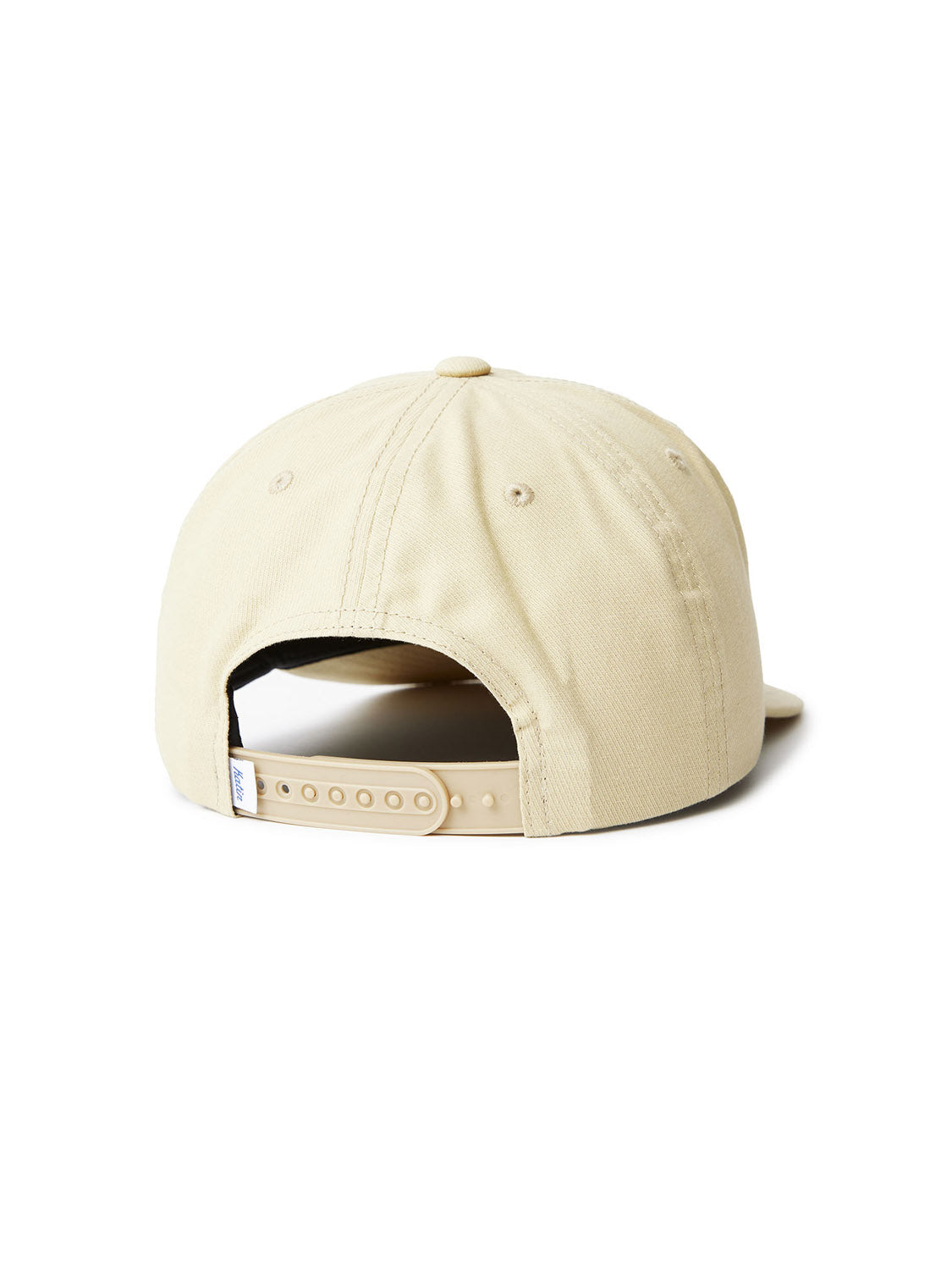 The Katin Voyage Hat is a beige cotton twill baseball cap, shown from the back, featuring an adjustable strap with plastic snaps, visible stitching, a top button, and custom embroidery. Part of the Katin headwear collection.