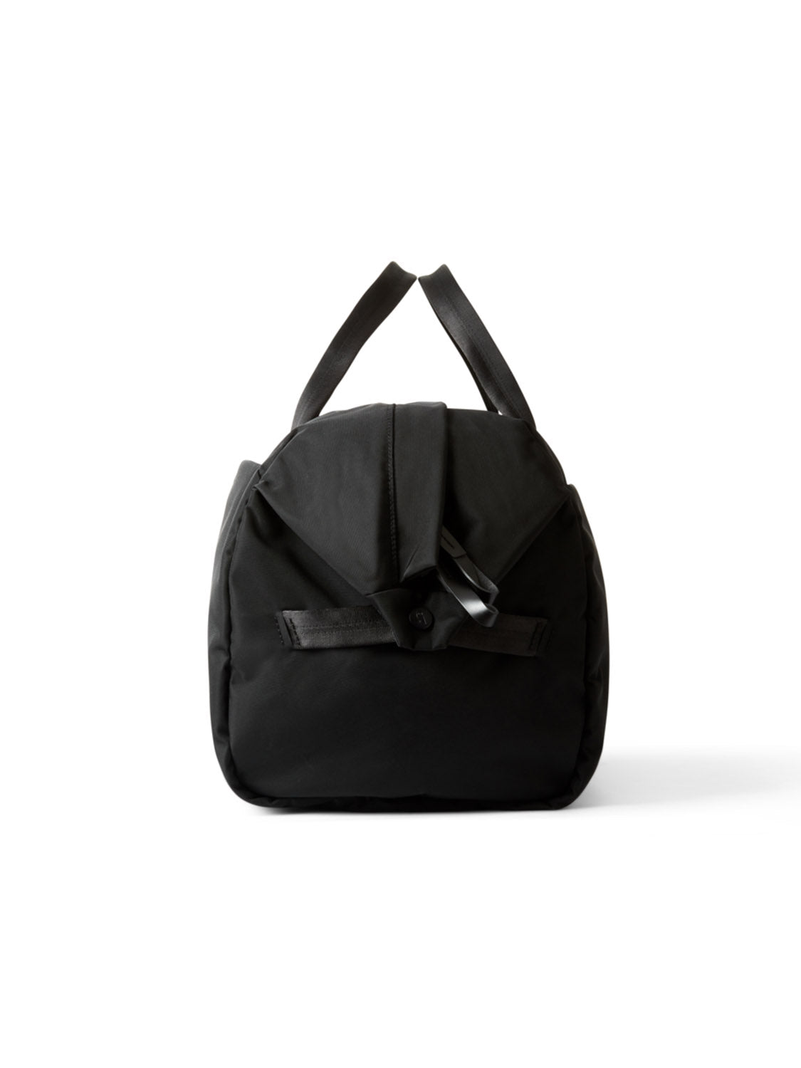 The Bellroy Classic Weekender - 45L is a minimalist duffel with dual handles, shown upright on a white background. It features a front flap with button and strap detail, making it ideal as a spacious bag for weekend travel.