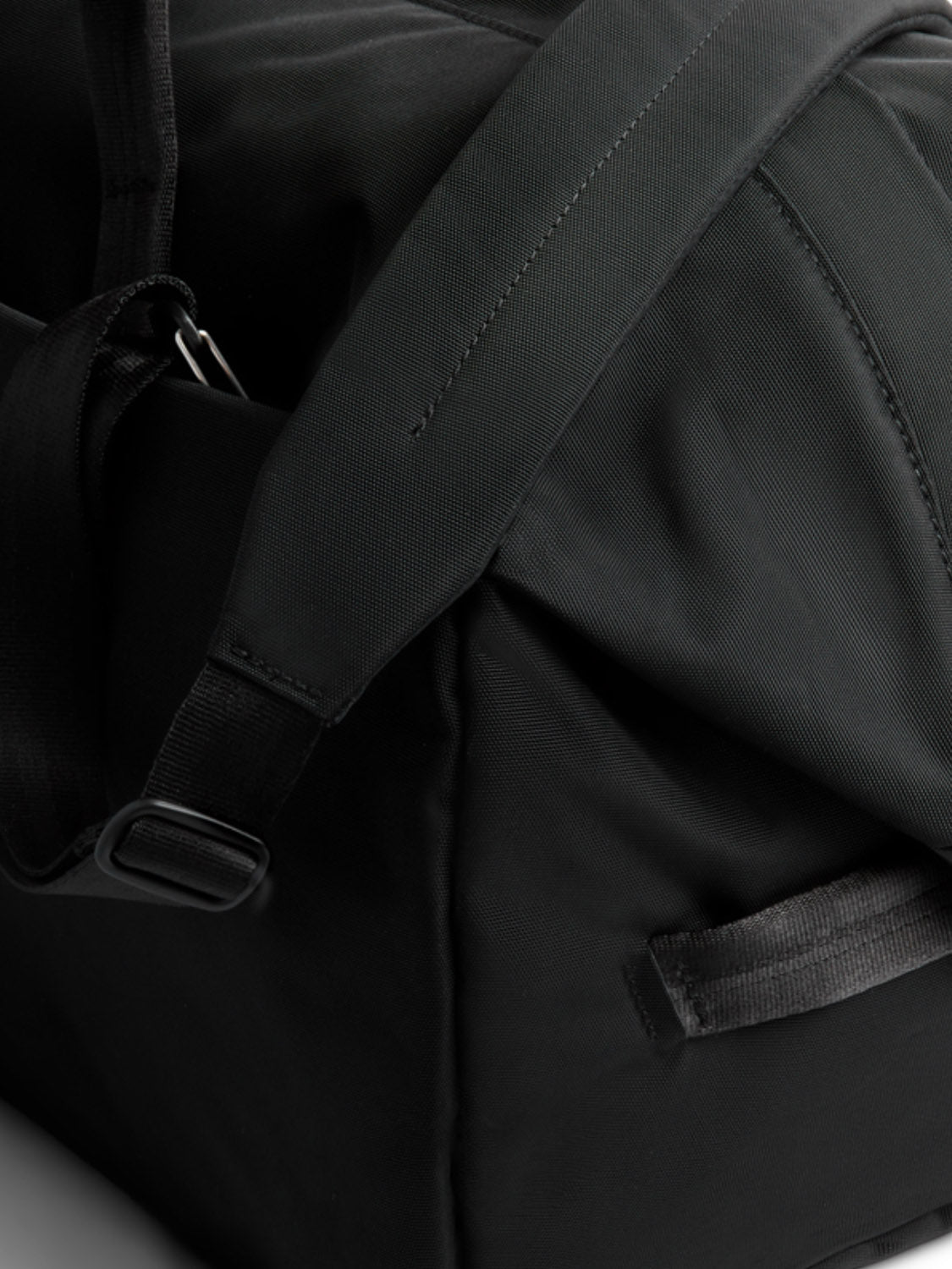 Close-up of the Bellroy Classic Weekender - 45L duffel bag, featuring sturdy fabric, padded shoulder strap, plastic buckle, side handle, durable stitching, and modern design—ideal for weekend travel.