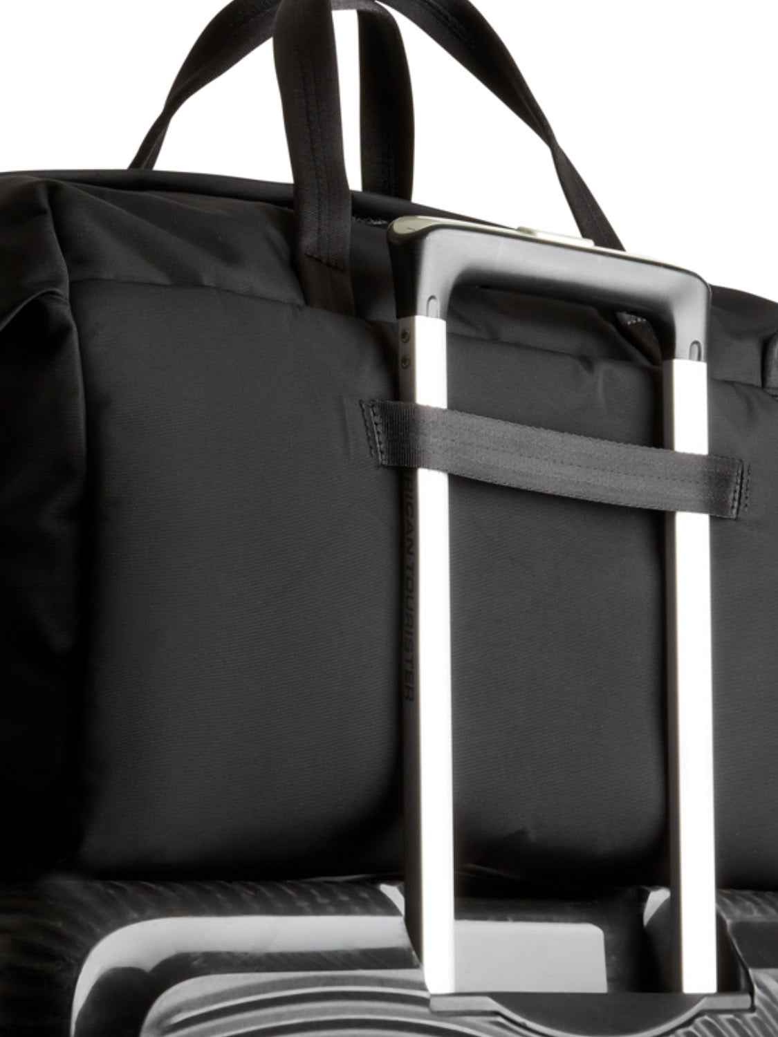 The Bellroy Classic Weekender - 45L fits securely over a suitcase’s telescopic handle, showcasing its minimalist design and sturdy handles—ideal for weekend travel.