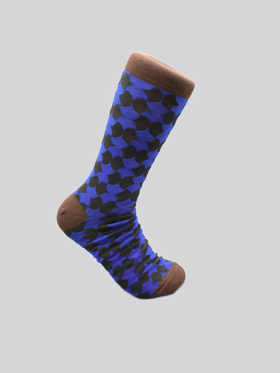 The Wiggle Graphic Sock by ID Menswear is a limited edition, single knee-high crafted from premium combed cotton. It features brown accents and a blue and black geometric design, shown on a light gray background.