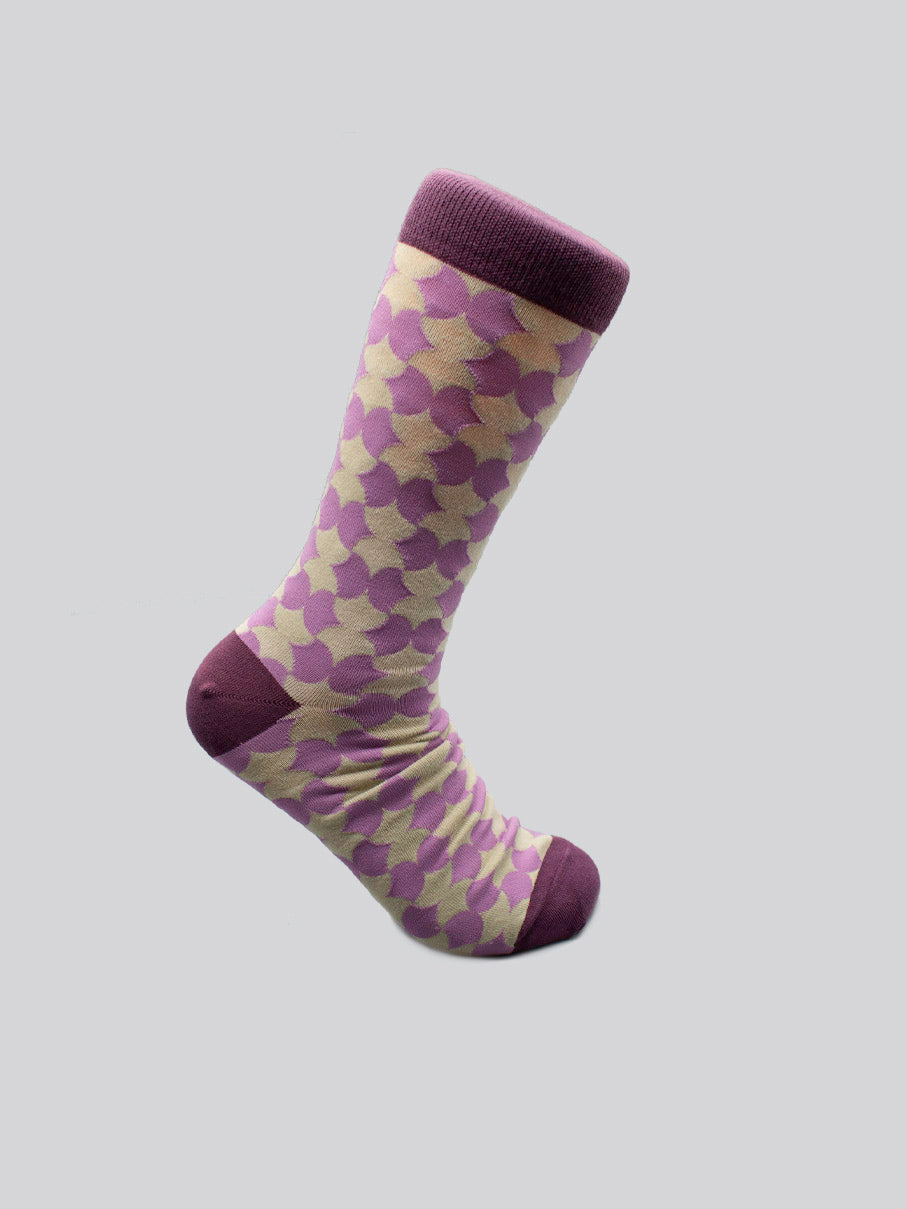 The Wiggle Graphic Socks by ID Menswear are limited edition combed cotton socks featuring a purple toe, heel, and cuff, plus pink, purple, and yellow overlapping circles on a light background. Shown on a plain grey surface.