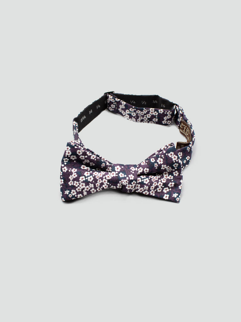 The Liberty of London Tana Lawn™ Wine Meadow bow tie by ID Menswear is handmade from soft cotton and features a delicate white and pink floral pattern on a light gray background.