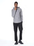A man poses against a white background wearing the Civil Society Wolfe Waffle Knit Hoodie in gray heather, paired with black pants and black dress shoes. One hand touches his chin while the other rests in his pocket.