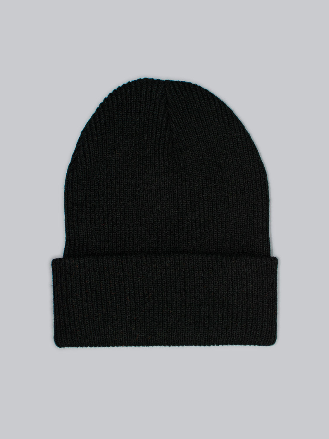 The Yonker Ribbed Acrylic Beanie by ID Menswear, a black rib-knit hat with a folded cuff made from soft acrylic, is displayed on a plain gray background.