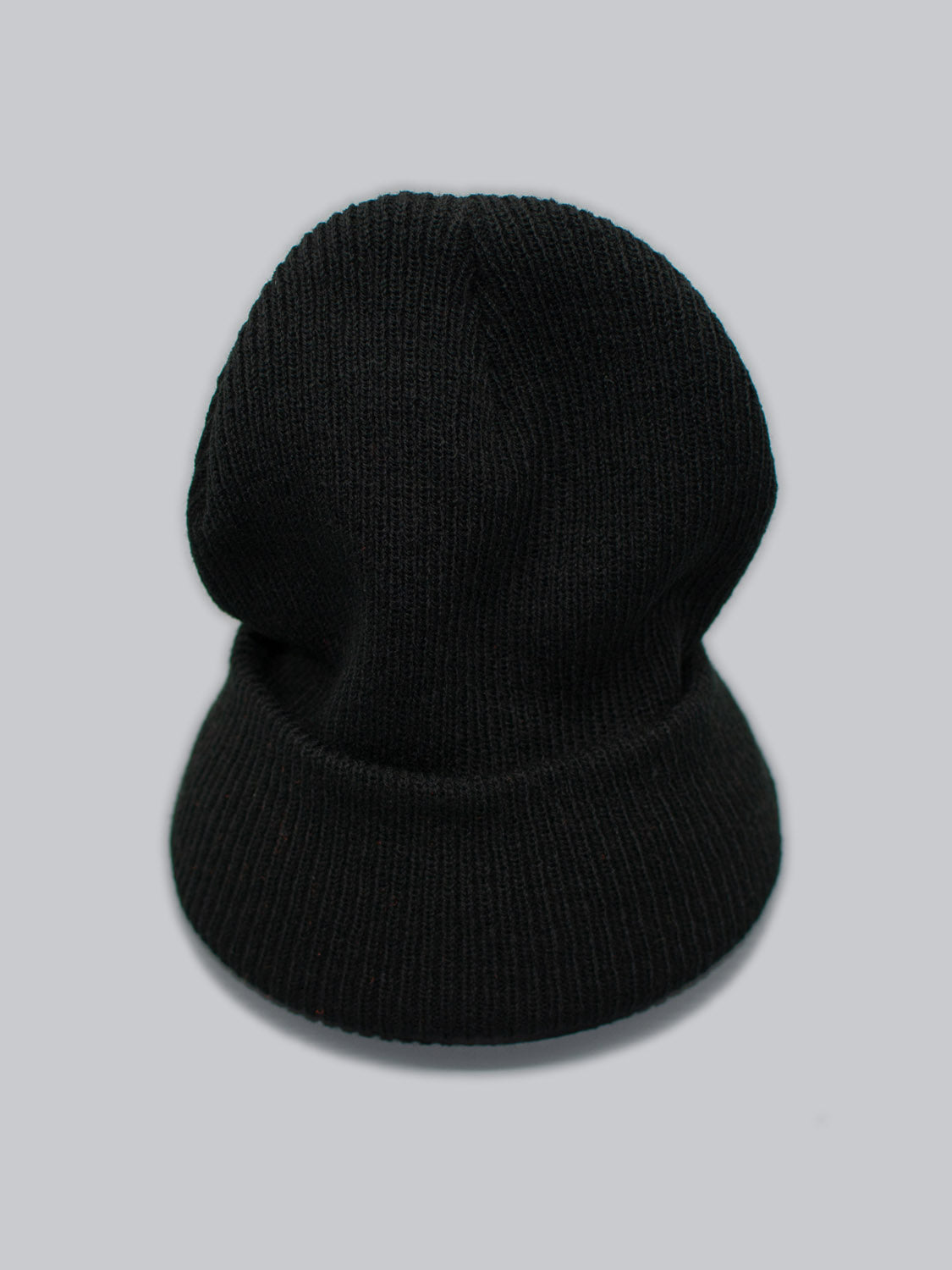 The Yonker Ribbed Acrylic Beanie by ID Menswear, featuring a folded cuff in black rib-knit design, is showcased against a light gray background.