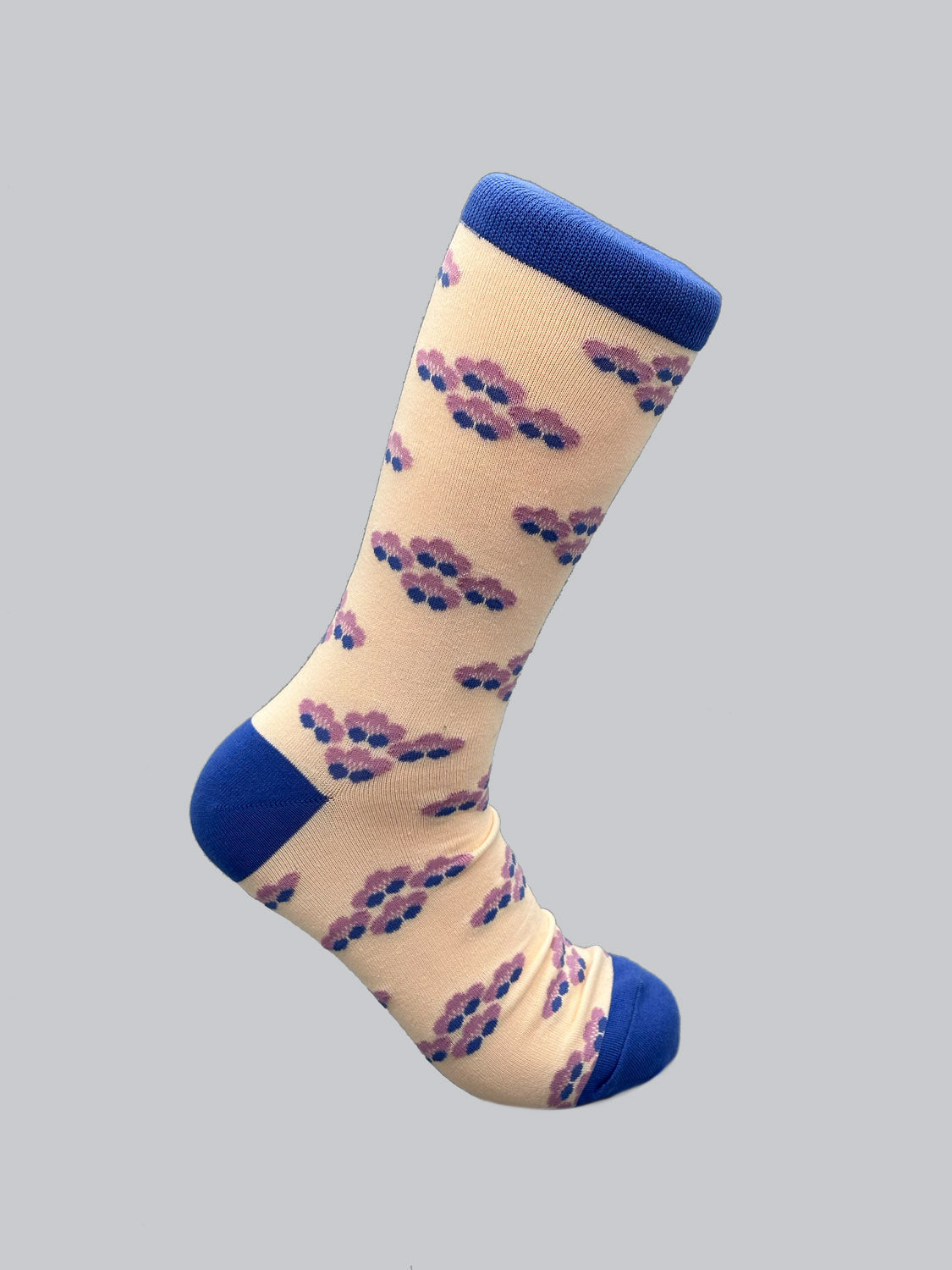 The Yuki Graphic Socks by ID Menswear feature a cream background adorned with pink and blue cloud designs. The toe, heel, and cuff are solid blue. Made from combed cotton for comfort, they are displayed against a plain gray backdrop.