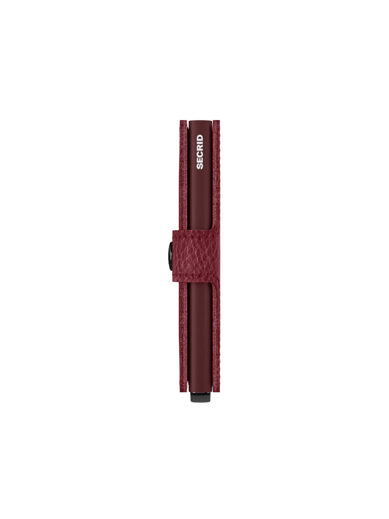 The Secrid Miniwallet Vegetable Tanned Leather in maroon stands upright, closed, showcasing textured leather and visible Secrid branding on the card holder. Built-in RFID protection ensures your cards stay secure.