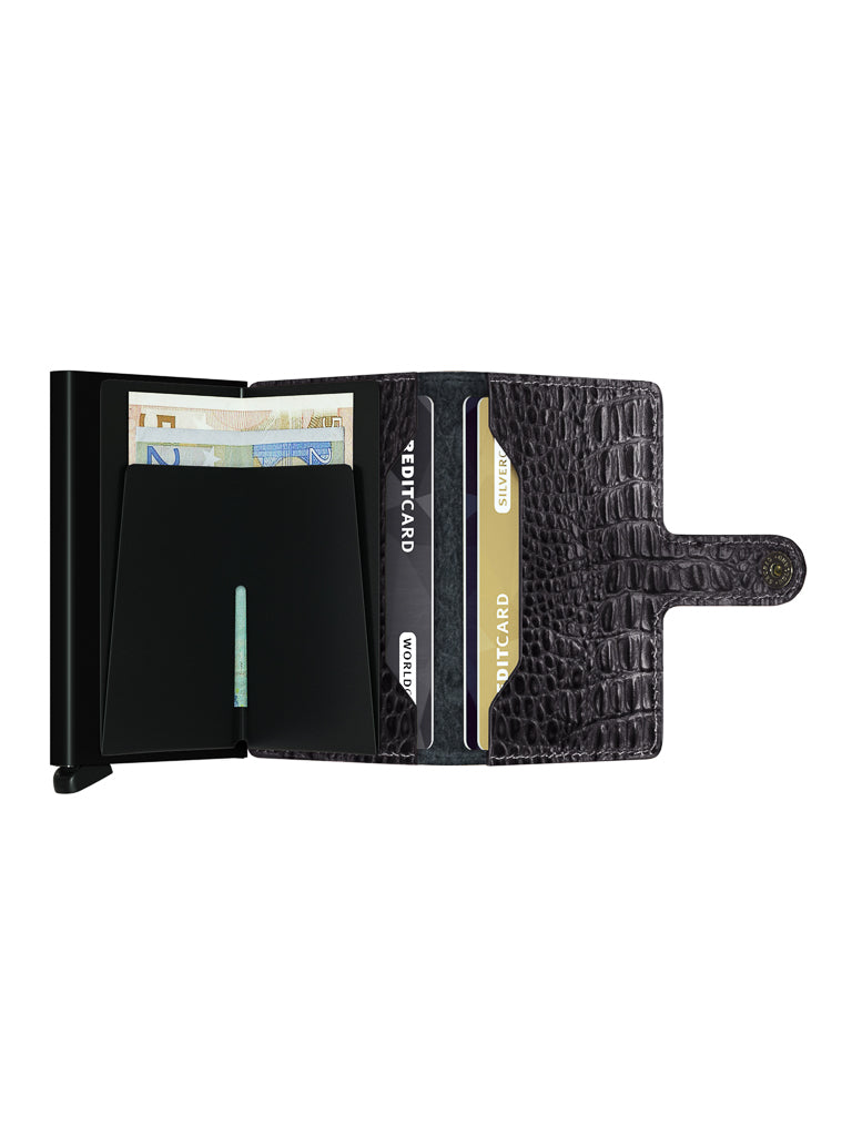 The Secrid Miniwallet Nile, an open black RFID wallet with a crocodile-pattern European leather cover, displays euro banknotes, two credit cards, and a snap button closure on a white background.