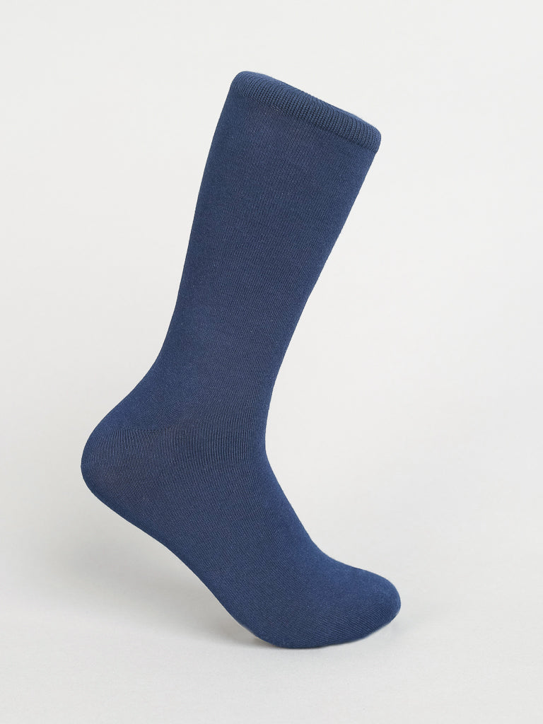 A single dark blue sock from ID Menswears Solid Color Combed Cotton Socks stands against a plain white background, showcasing its smooth, seamless texture, making it ideal for comfortable everyday wear.