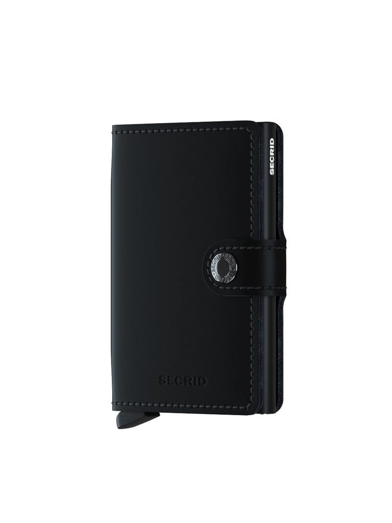 A Secrid Miniwallet Matte Finish Leather, in black with visible stitching and snap button closure, stands upright on a white background. The compact wallet displays the SECRID brand name embossed on the lower front and edge.