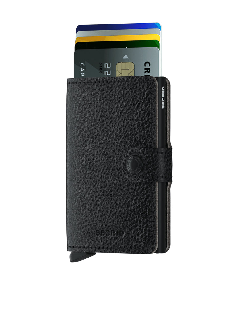 The Secrid Miniwallet Vegetable Tanned Leather in black features textured, vegetable-tanned leather, a button clasp, and partial opening to reveal colorful cards. The wallet offers RFID protection and displays the Secrid logo on the front.