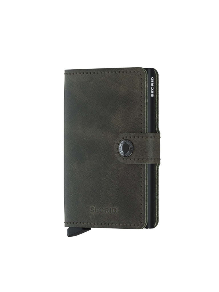 The Secrid Miniwallet Vintage Leather is a dark green wallet with a snap closure, visible card edges, and the Secrid logo embossed on the front.