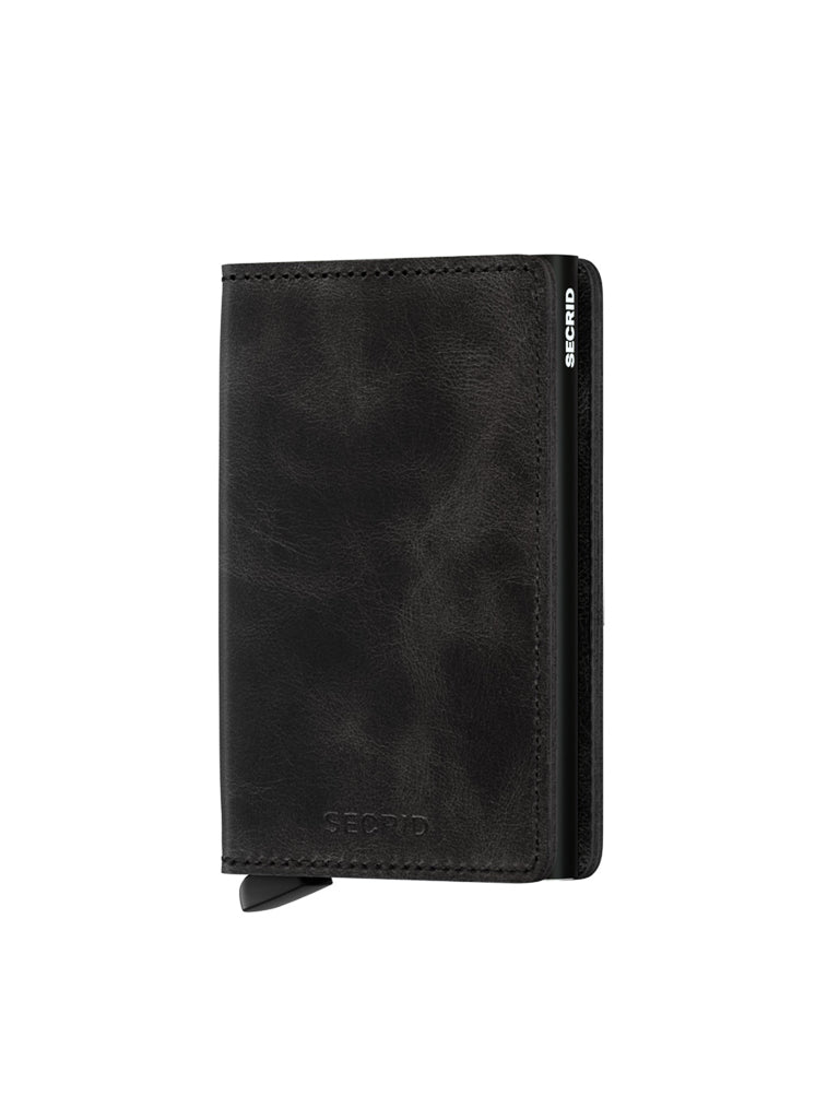 The Secrid Slimwallet Vintage Leather, crafted from black leather, stands upright on a white background with a visible metallic edge and tab at the bottom, and offers RFID protection.