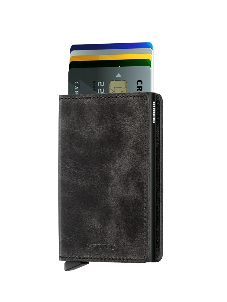 The Secrid Slimwallet Vintage Leather in black, featuring RFID protection and a textured finish, displays four colorful cards partially visible at the top against a white background.