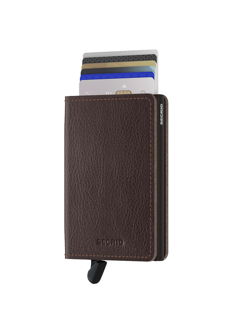 The Secrid Slimwallet Vegetable Tanned Leather is a brown wallet featuring a black bottom lever for easy card access, with several cards partially extended and built-in RFID protection.