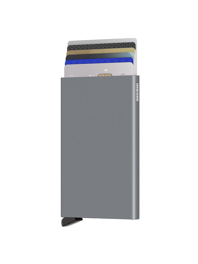 The Secrid Cardprotector Minimal Wallet is a slim, gray metal wallet with partial credit cards visible inside. A small black lever extends from the lower left corner, and "Secrid" is printed along the right edge of this RFID-safe accessory.
