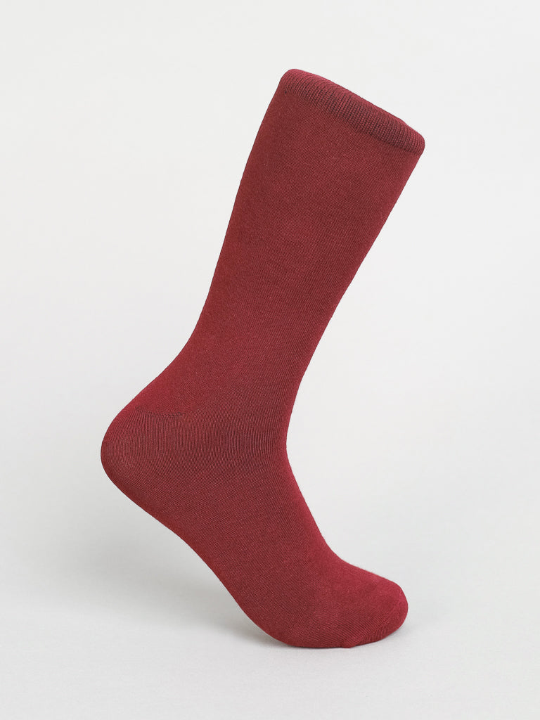 A single red ID Menswear Solid Color Combed Cotton Sock stands upright against a white background. Its crafted from combed cotton with a simple design and reinforced toe and heel, ideal for comfortable everyday wear.