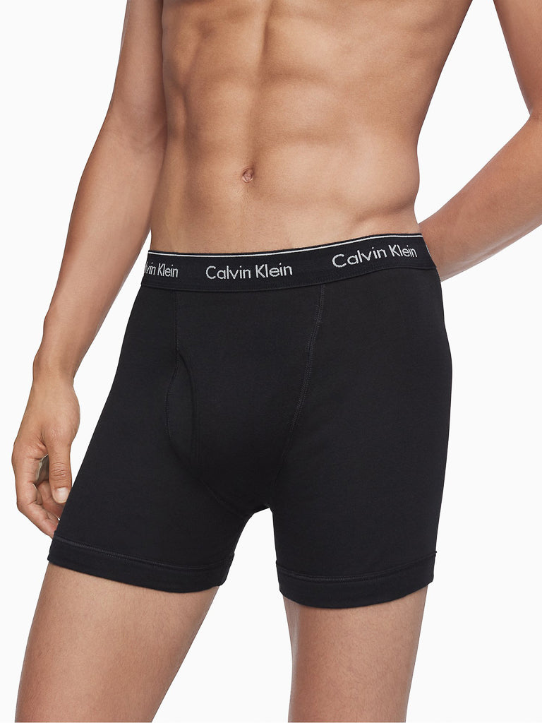 A man is wearing Calvin Klein NB4003 3-Pack Cotton Classic Boxer Briefs with a branded waistband; his torso and upper legs are shown against a plain white background.