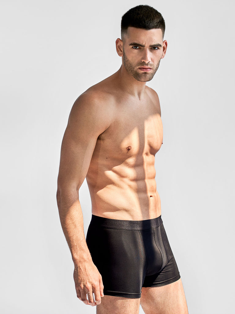 A muscular man with short dark hair stands against a plain background, wearing Bread & Boxers - 3 Pack Boxer Briefs. He exudes confidence as light and shadow accentuate the sleek contours of his fit physique, highlighted by the classic fit and elastic waistband.