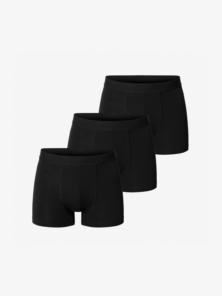 A 3-pack of Bread & Boxers mens boxer briefs is arranged in a staggered line on a light background. Each black pair, made from organic cotton, boasts a simple design with an elastic waistband for comfort.