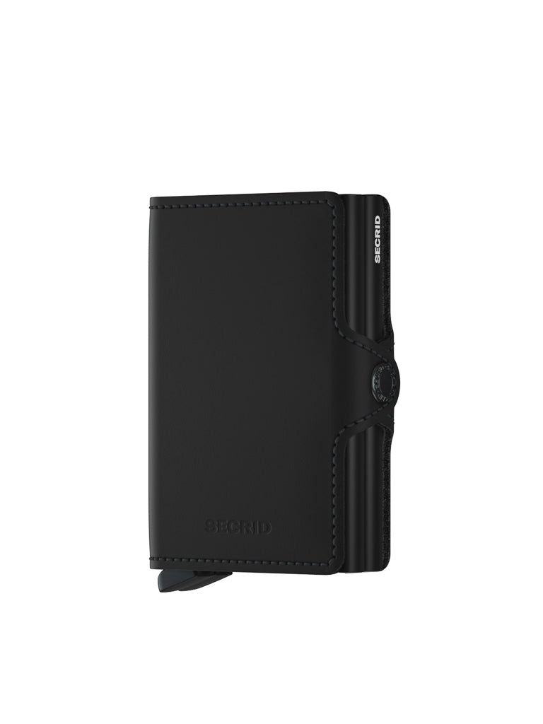 A black Secrid Twin Wallet in matte finished leather with a minimalist fold-over design and side button clasp, shown on a white background.