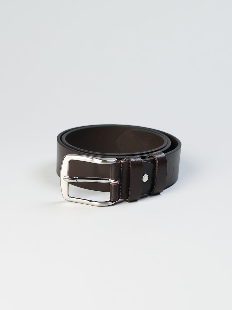 A coiled dark brown 4550 Made in Italy Leather Belt by ID Menswear, featuring a shiny silver rectangular buckle, is displayed on a plain light gray background.