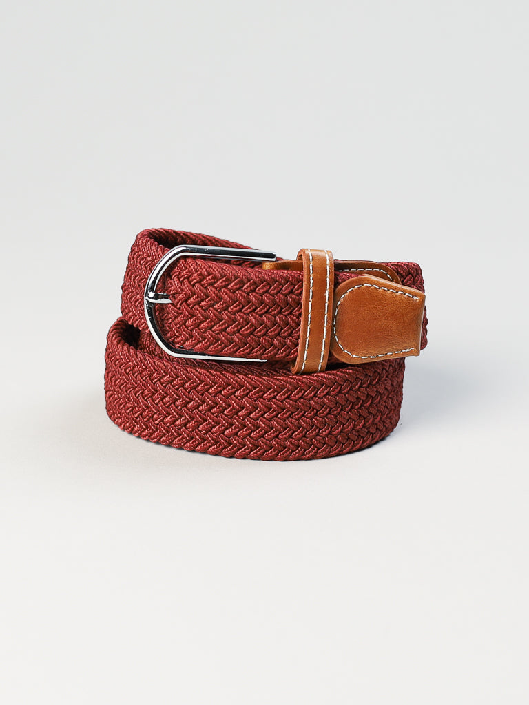 The ID Menswear ID Braided Stretch Woven Belt features a coiled woven design in red, with a metal buckle and brown leather accent, all set on a plain white background.