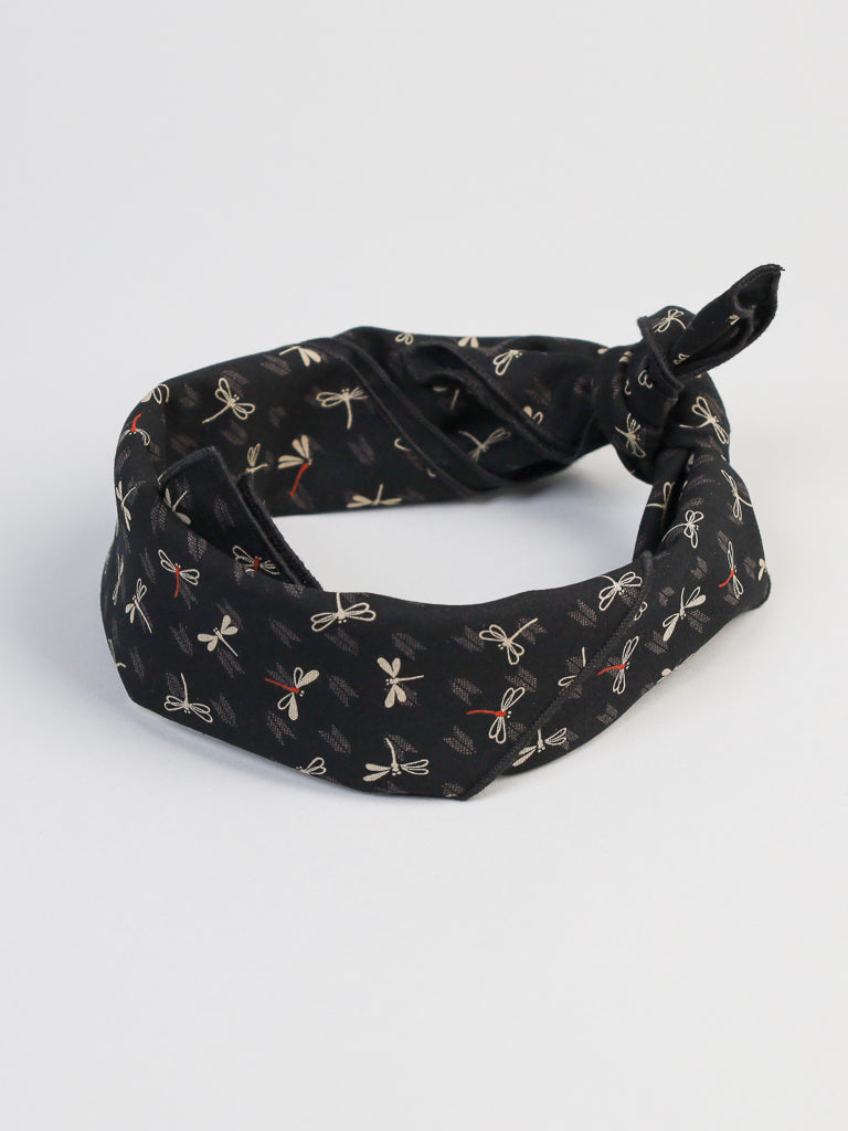 The Black Dragonfly Bandana by ID Menswear, crafted from 100% cotton, features a circular fold and a delightful pattern of small white and red outlined dragonflies on a plain white background.