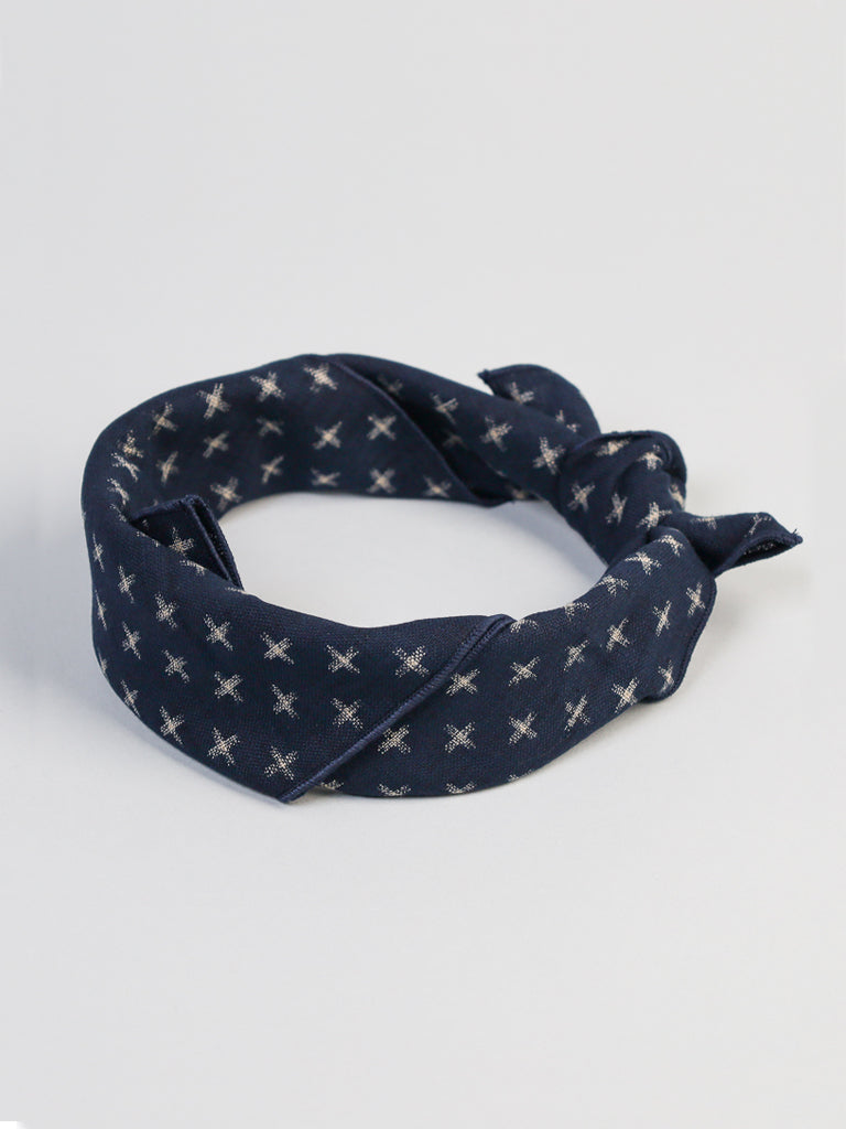 A Ronin Kasuri Bandana by ID Menswear, featuring navy blue color with white crosses and Kasuri-like hatches, is neatly folded on a plain white background.