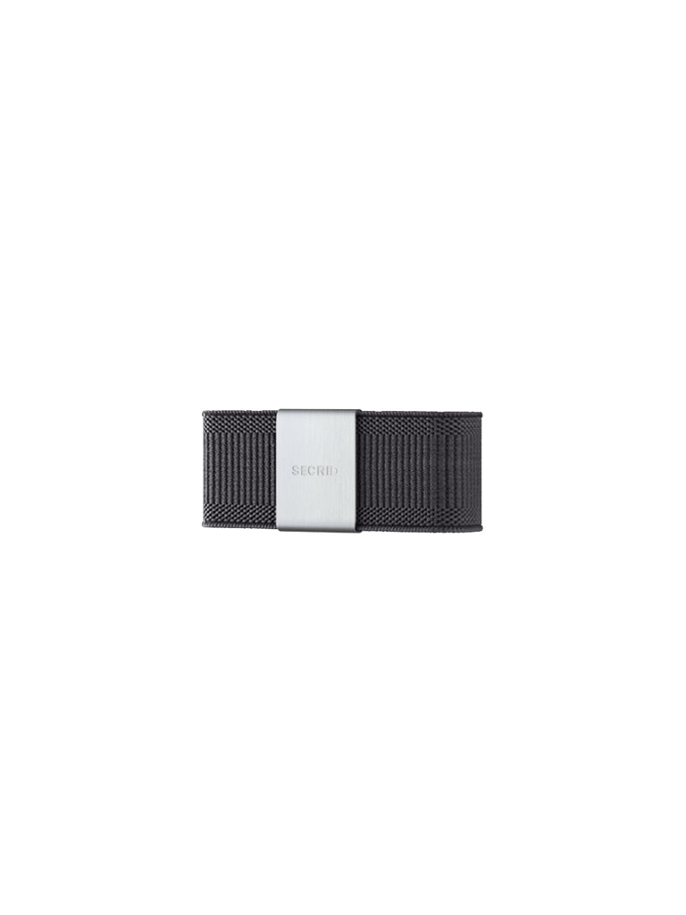 A Secrid Money Band Cardprotector Add-on in black woven fabric, featuring a brushed silver metal plate engraved with SECRID, is displayed on a plain white background.