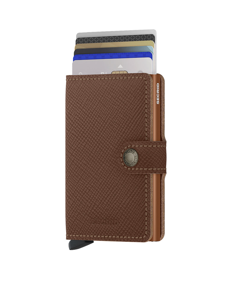 The Secrid Miniwallet Saffiano Leather is a brown textured wallet with RFID protection, a snap button closure, several visible credit cards, and a black tab at the bottom.