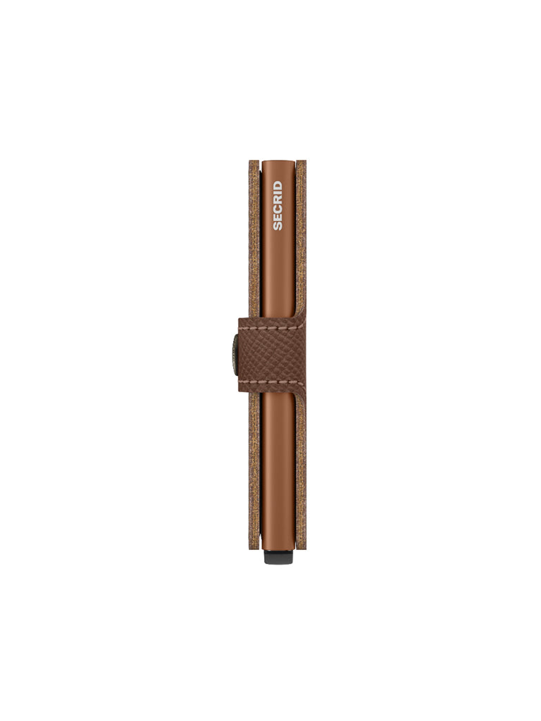 The Secrid Miniwallet Saffiano Leather, in brown with a textured strap and visible logo, offers RFID protection and is shown standing upright against a white background.