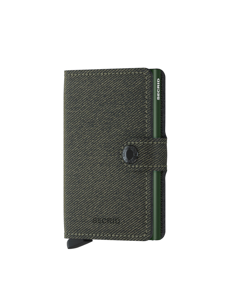 The Secrid Miniwallet Twist Twill Leather is a compact dark green wallet featuring textured twill leather, a black snap closure, an exposed aluminum card holder for easy access, RFID protection, and the Secrid logo near the top edge.