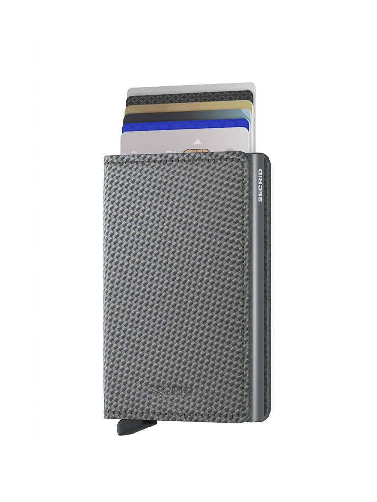 The Secrid Slimwallet Carbon Fibre Pattern Leather holds multiple bank cards upright, features a gray textured finish, RFID protection, a discreet logo on the side, and a small black pull tab at the bottom.
