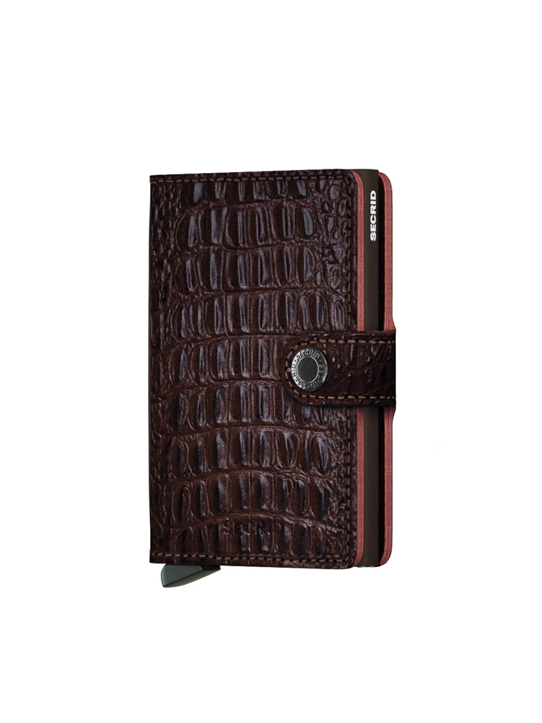 The Secrid Miniwallet Nile is a brown, crocodile-patterned RFID wallet made from premium European leather with a snap button closure and Secrid branding on the side, shown slightly open to reveal cards inside.