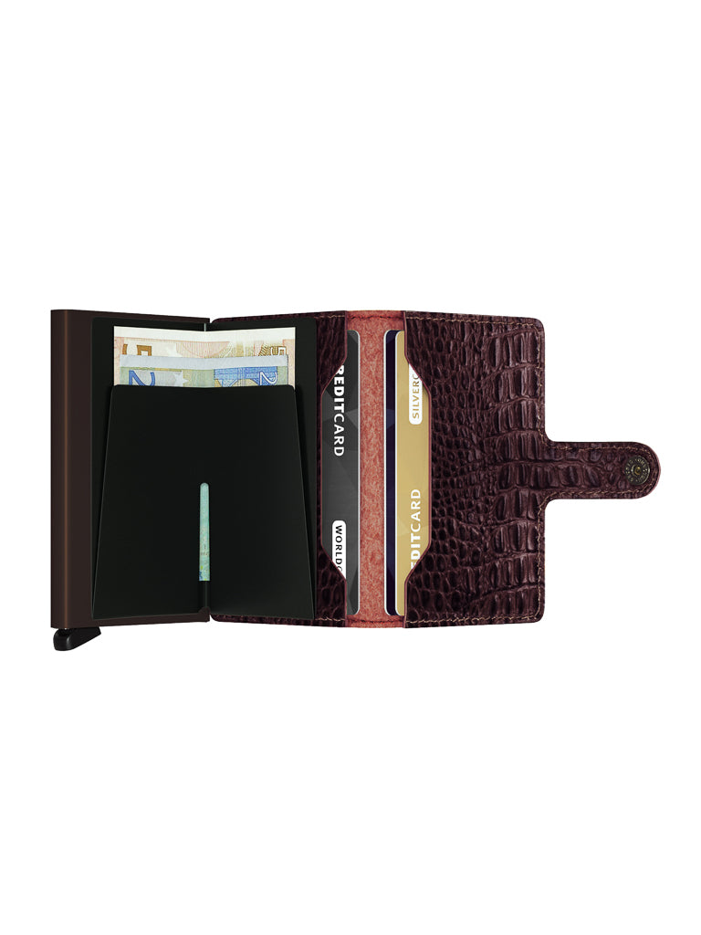 The Secrid Miniwallet Nile, crafted from textured brown European leather, features RFID protection, a snap closure, and an organized interior with euro banknotes and cards in designated slots.